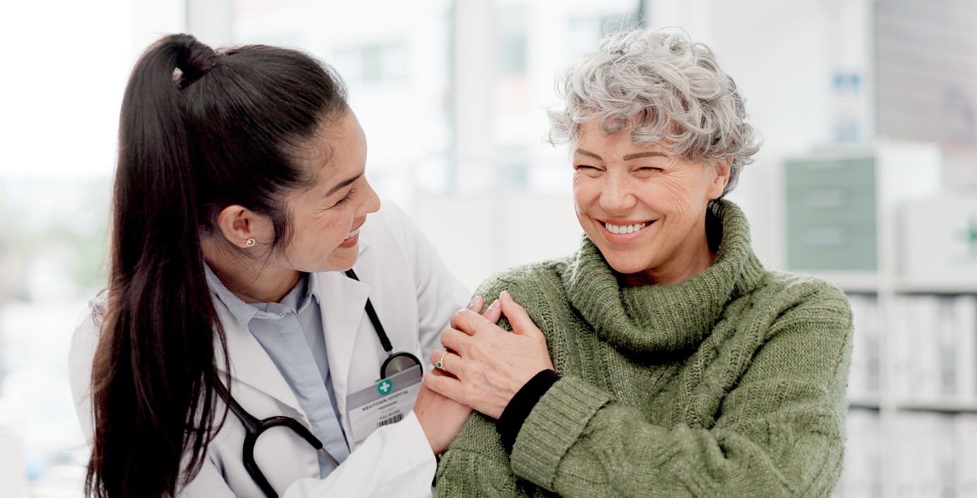 Eine Ärztin und eine Patientin lache gemeinsam. 