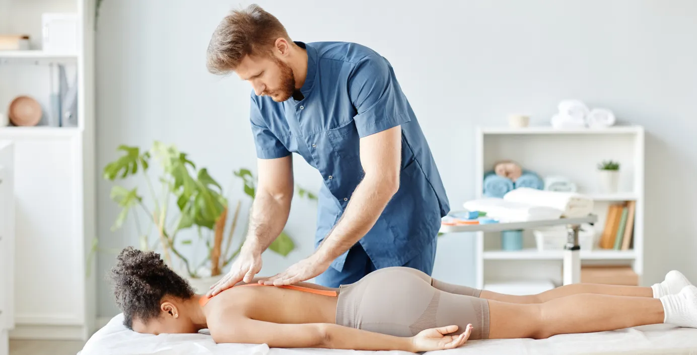 Ein Chiropraktiker behandelt den Rücken einer Patientin.