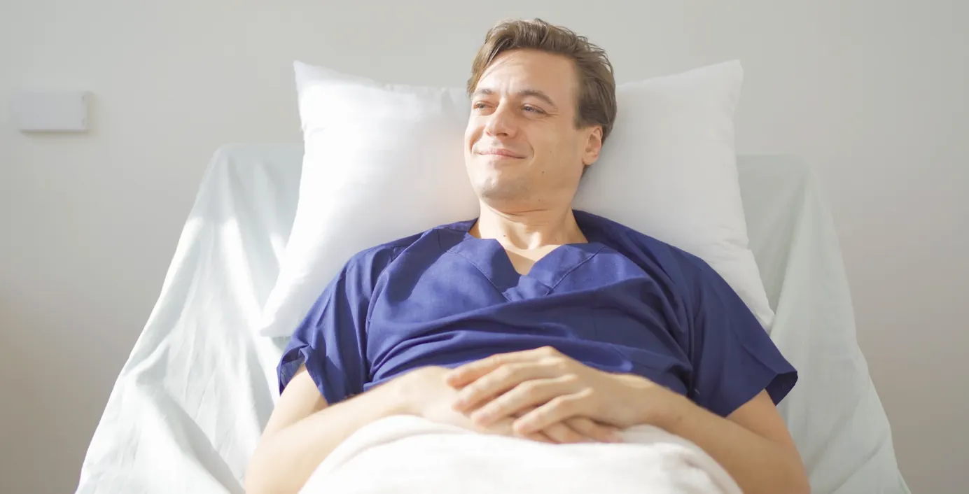 Ein Patient liegt in einem Krankenhausbett.