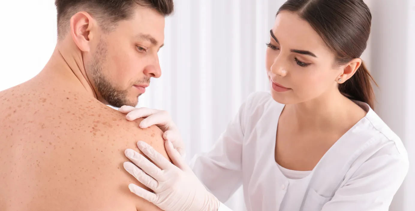 Ein Patient bekommt seine Haut von einem Arzt untersucht.