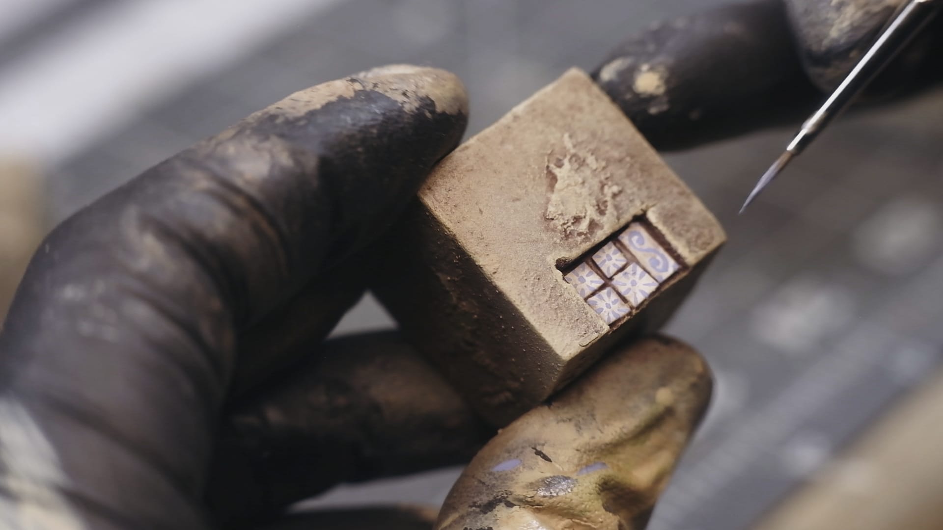 Close-up of painting azulejo style tiles on a cube.