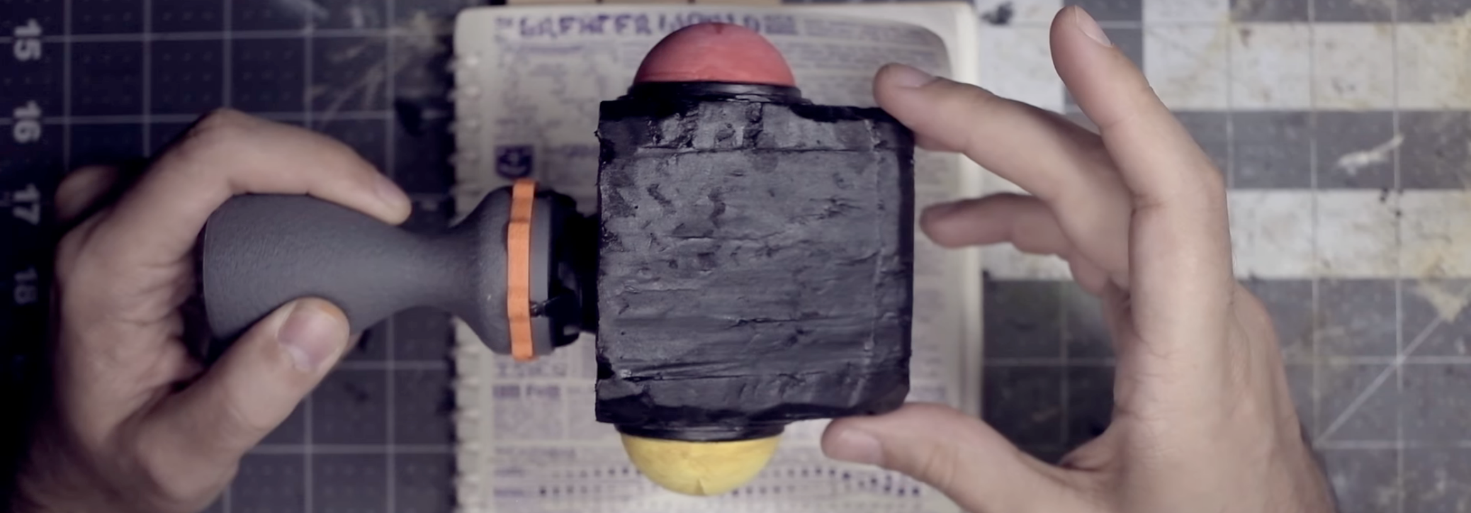 Still of my hands holding a crude prop representing the head of the sky-serpent Jörmukunda.