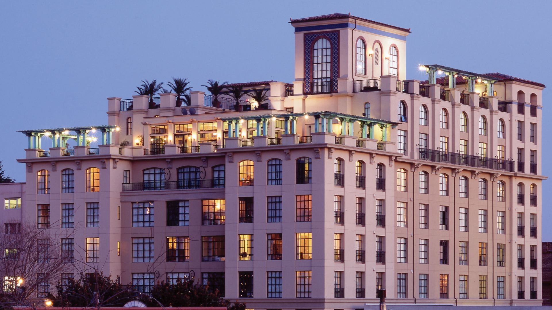 A 7-story modern apartment building with decorative features and lighting