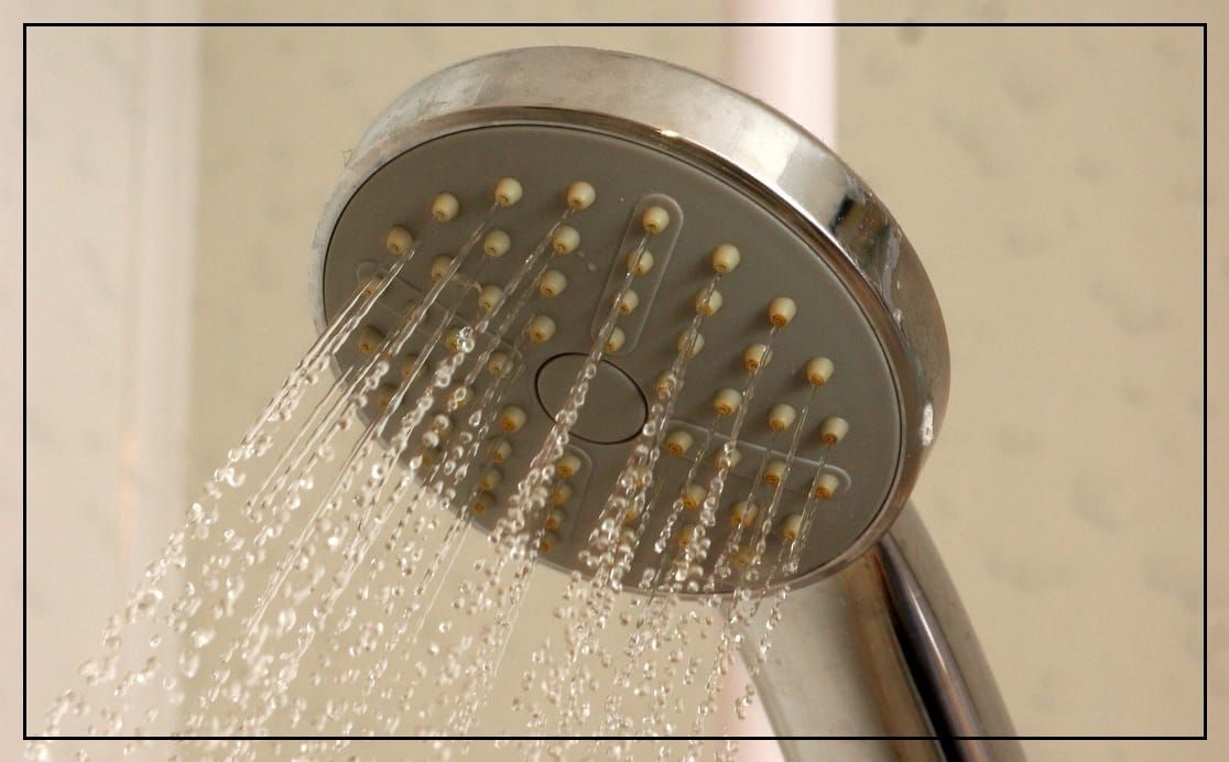 A hand-held shower head with water coming out. 