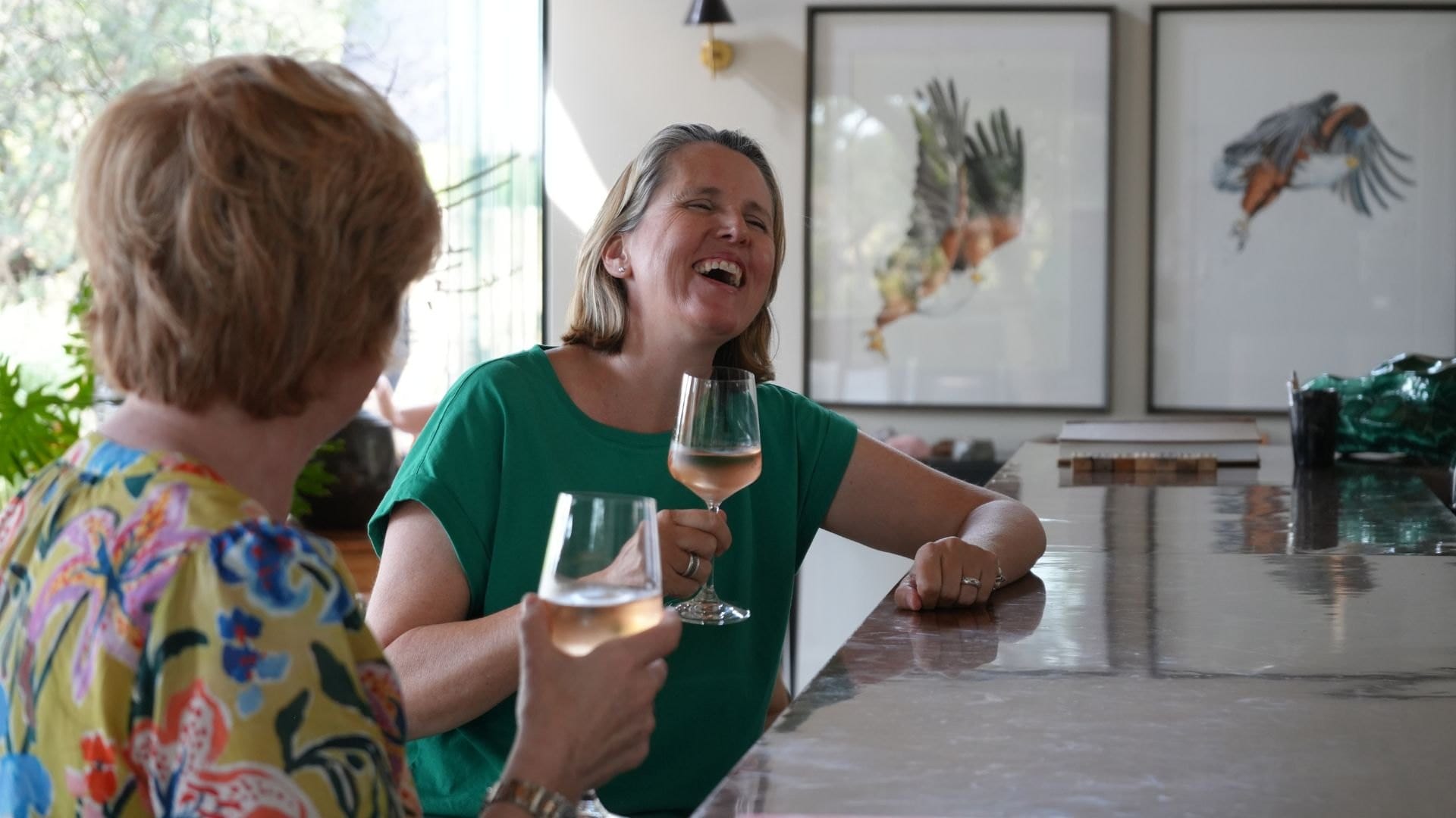Sian Loehrer laughing with Vikki Jackson over a glass of wine at the bar at Monwana Game Lodge