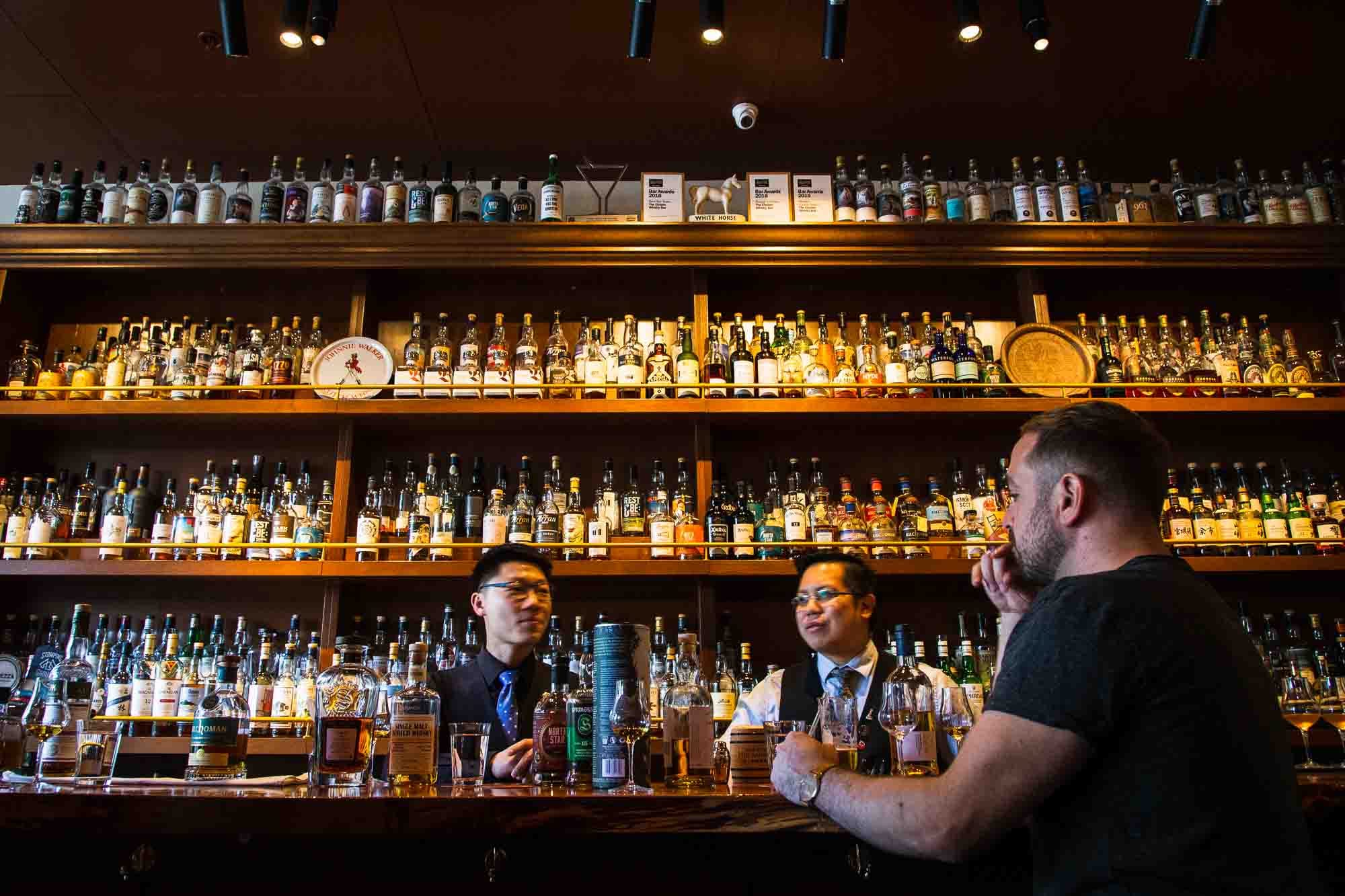 Owners Kelvin Low and Yao Wong behind the bar at The Elysian Whisky Bar in Fitzroy. Photo: Boothby