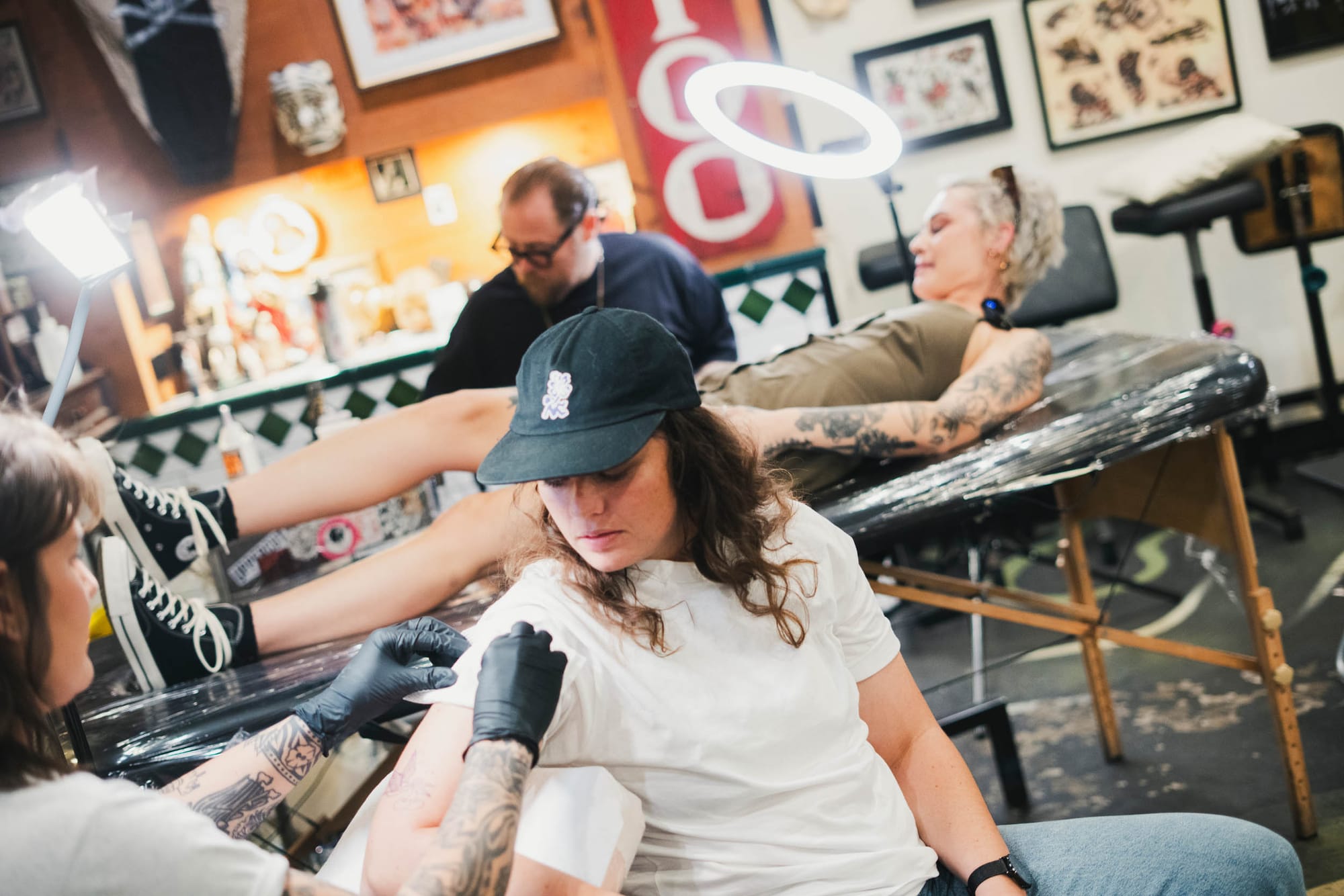 Bri and Kayla wait for the tattoo guns to power up. Photo: Boothby