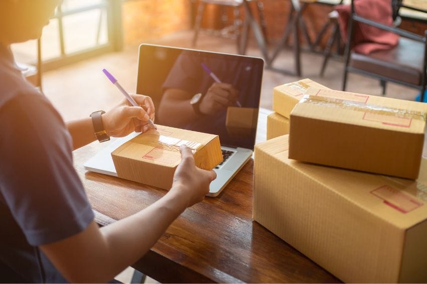 An entrepreneur labeling boxes to be sent out to customers