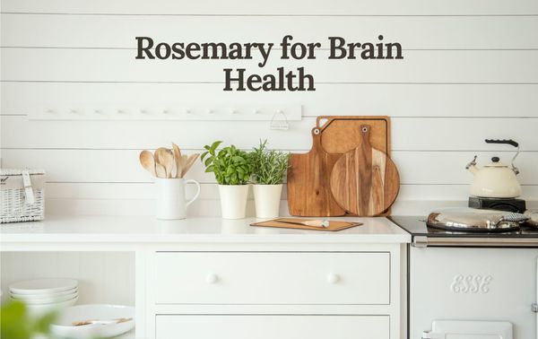 A kitchen countertop with potted rosemary and basil, wooden cutting boards, and cooking utensils