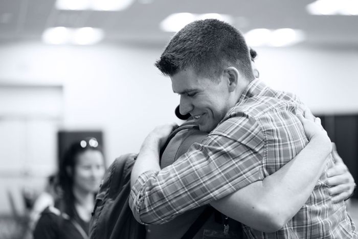 Two community members embracing warmly at a conference