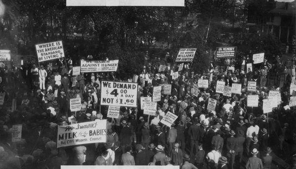 A large crowd gathers at LA Plaza, Los Angeles on  November 7, 1933 to participate in a Hunger March. The protest was organized by the Communist Party and the United Front Conference Against Hunger.   From the Los Angeles Public Library's Harry Quillen photo collection.  The photographer is Harry Quillen. 