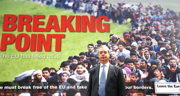 United Kingdom Independence Party (UKIP) leader Nigel Farage standing in front of a UKIP poster showing a crowd of alleged EU immigrants with an obvious implication of a Muslim horde. 