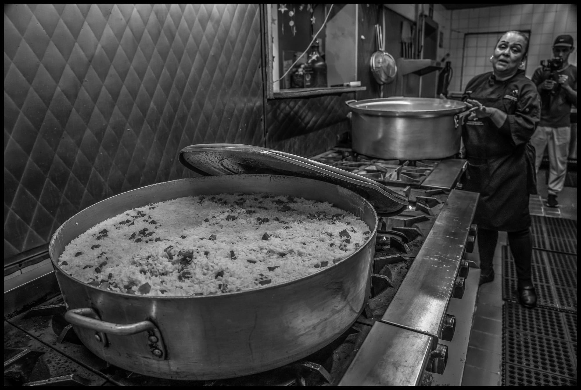 Mexicans deported into Tijuana often have no home in Mexico and nowhere to go. Without money many live on the streets and stave off hunger through a food distribution center downtown organized by World Food Kitchen. Araceli Claro prepares food at the distribution center. All photos © David Bacon.