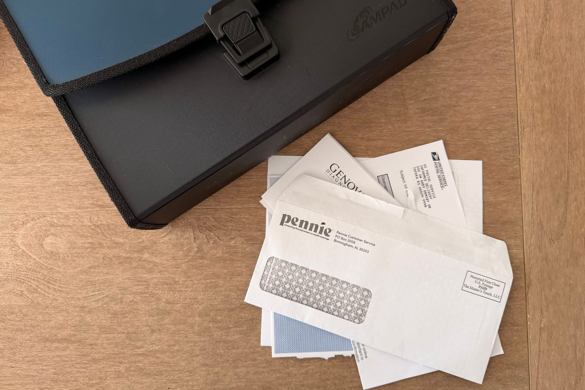 Mail and bills stacked next to a file folder on a table