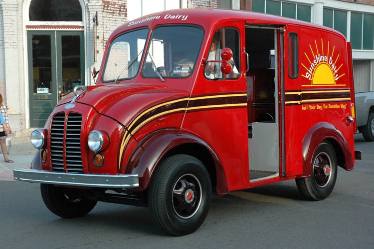 Divco dairy truck,1948, painted red with a yellow and black stripe and a logo for Sunshine Dairies
