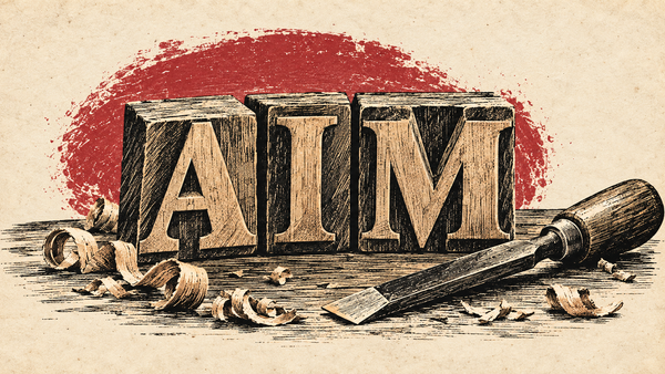 Three woodcut letter blocks of the letters AIM with a wood chisel and shavings in front of it.
