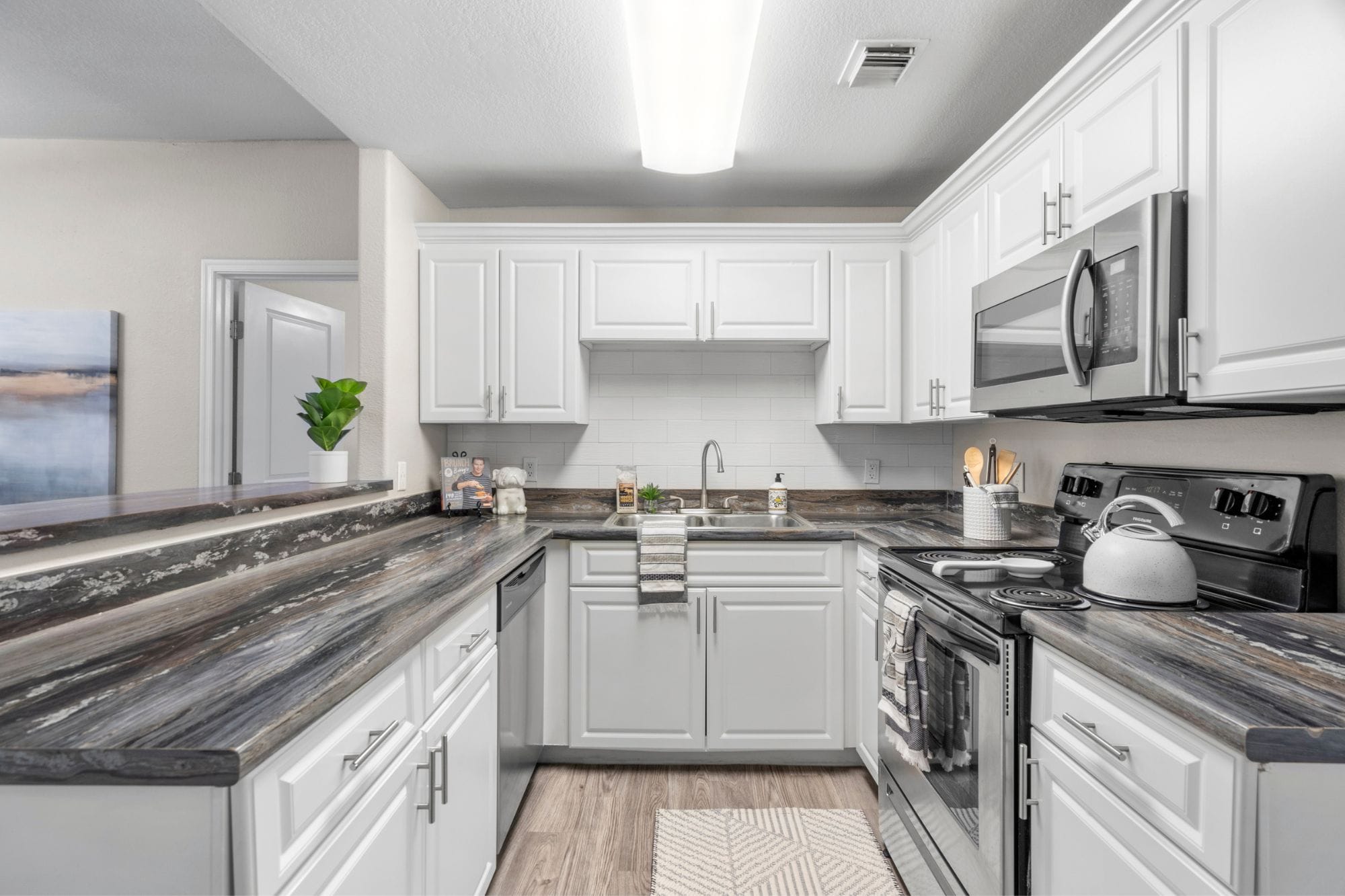 A full equipped kitchen with stainless steel appliances inside of an apartment at Luxe 1930, an apartment community in Mesa, AZ.