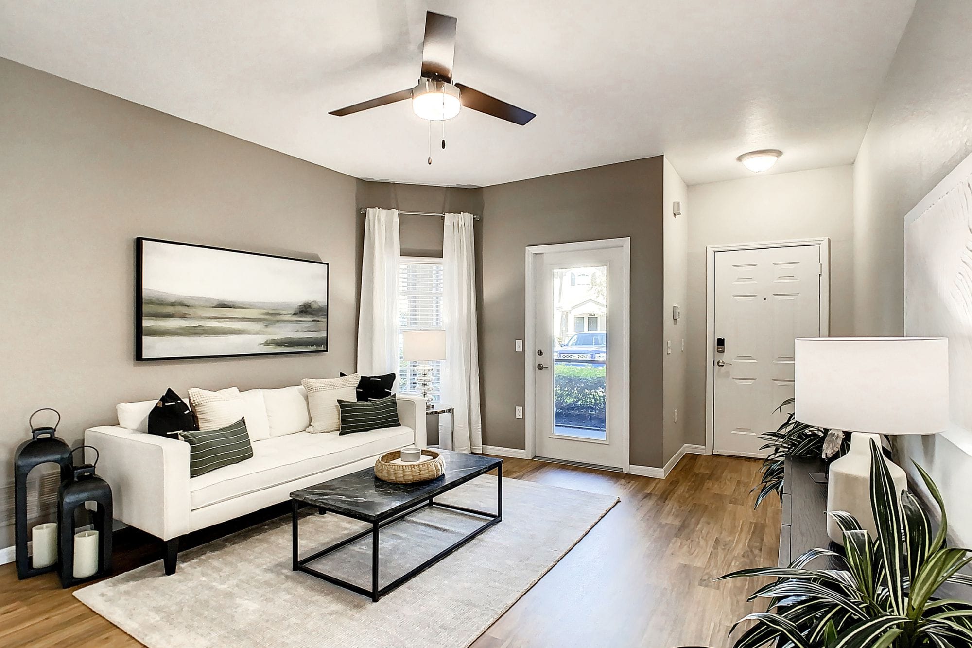 A large living room with wood-style flooring and modern design at Lakes of Tuscana Apartments in Port Charlotte, FL
