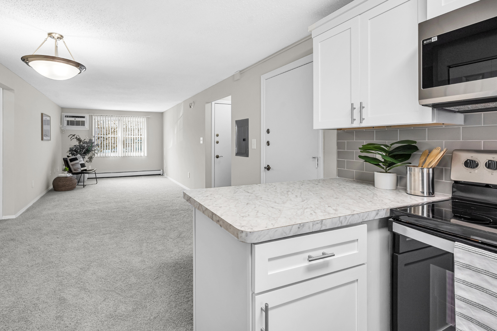 An interior of an apartment home at Sugarloaf Estates displaying an open-concept floor plan flooded with natural light.