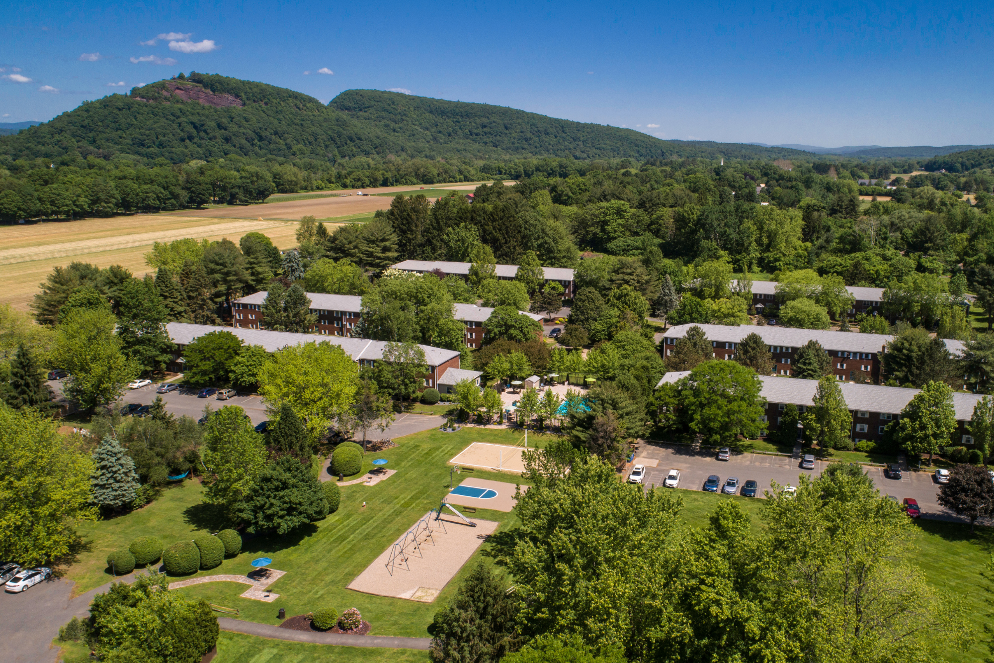 An aerial view of Sugarloaf Estates Apartments, with sprawling countryside and mountain views nearby.
