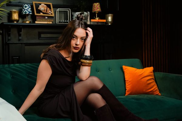 Hazel Rose sitting on a sofa in a quaint room
