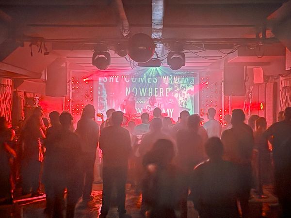 People looking at a red-lit stage
