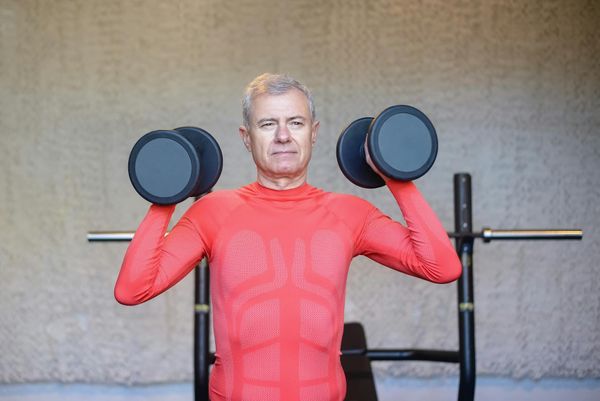 Senior man strength training indoors — promoting active longevity and healthy aging