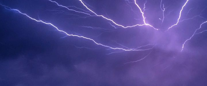 Clouds glow with purple lightning.