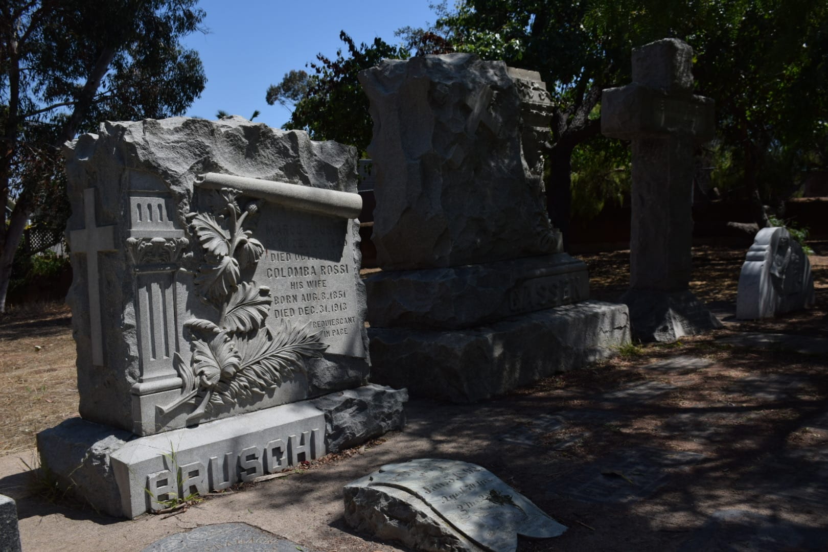 A gravestone embossed with a column, leaves and a cross 