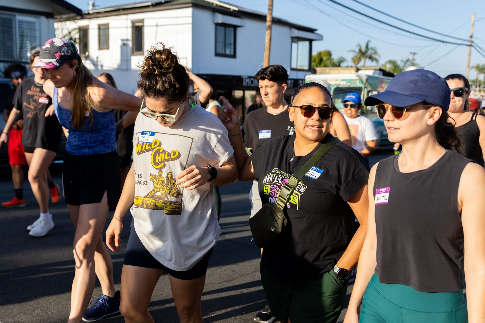 A group of people wearing name tags and workout clothes get ready to go for a run.
