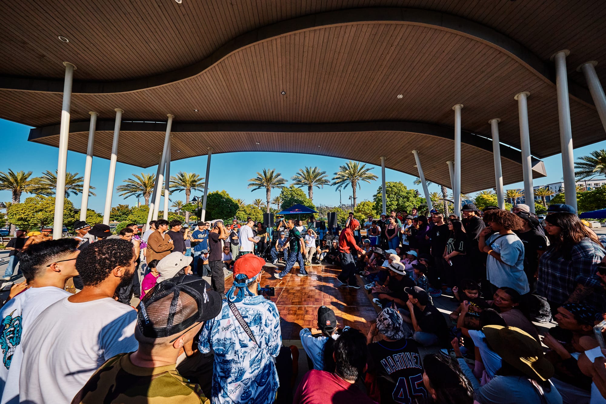 A crowd watches people breakdance outside