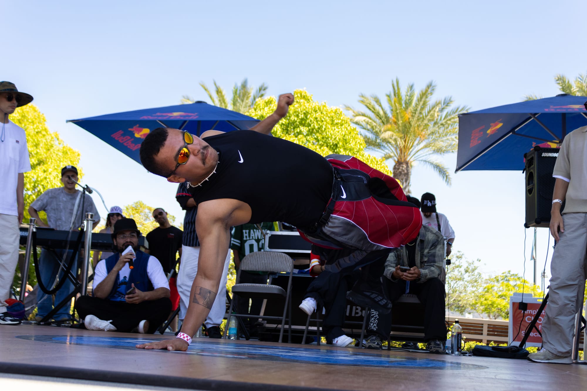 A dancer performs in a breaking competition outside in a park.