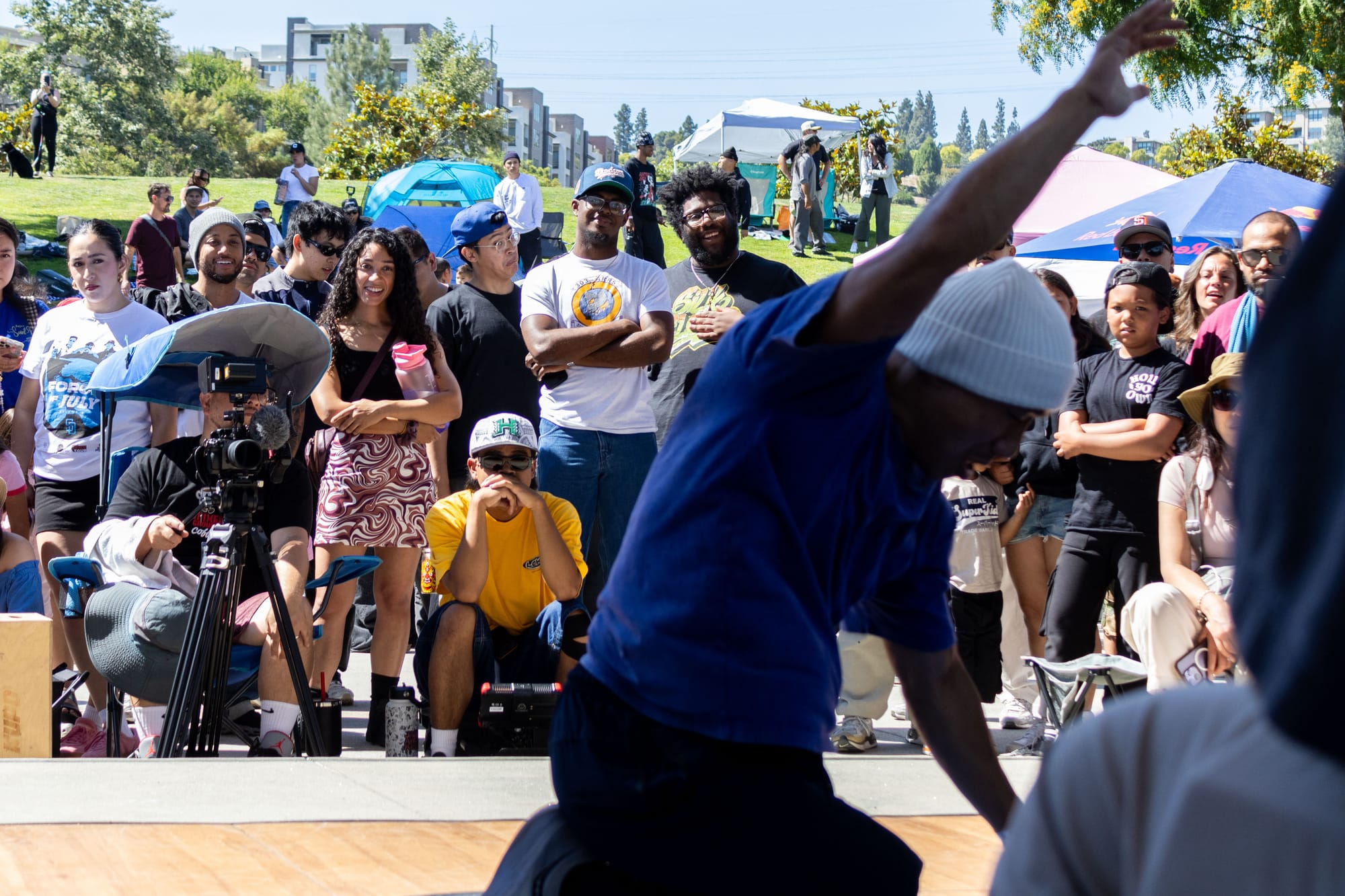 People watch a breaking performer dance outside in a park