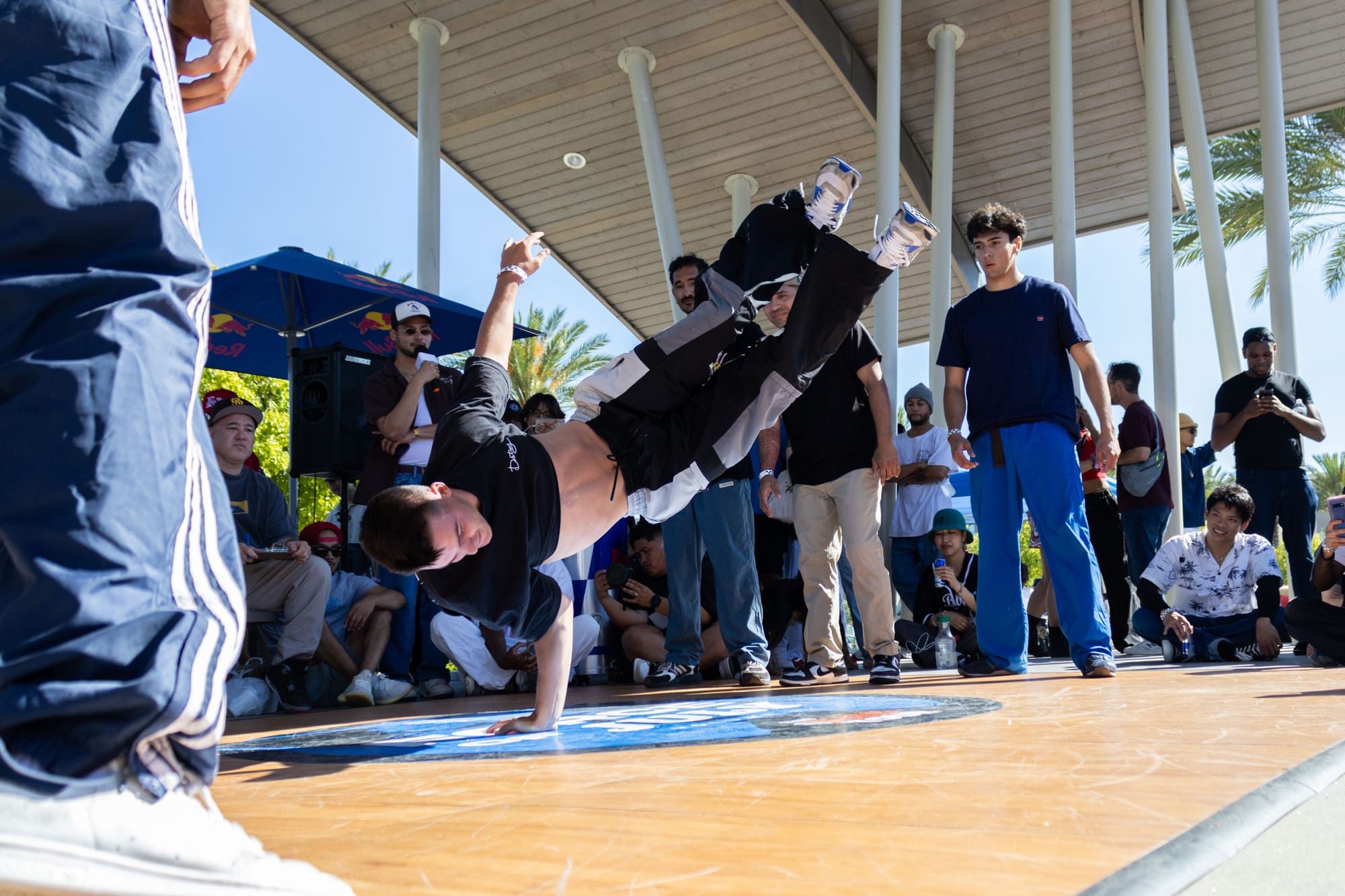 A dancer performs in a breaking competition outside in a park.