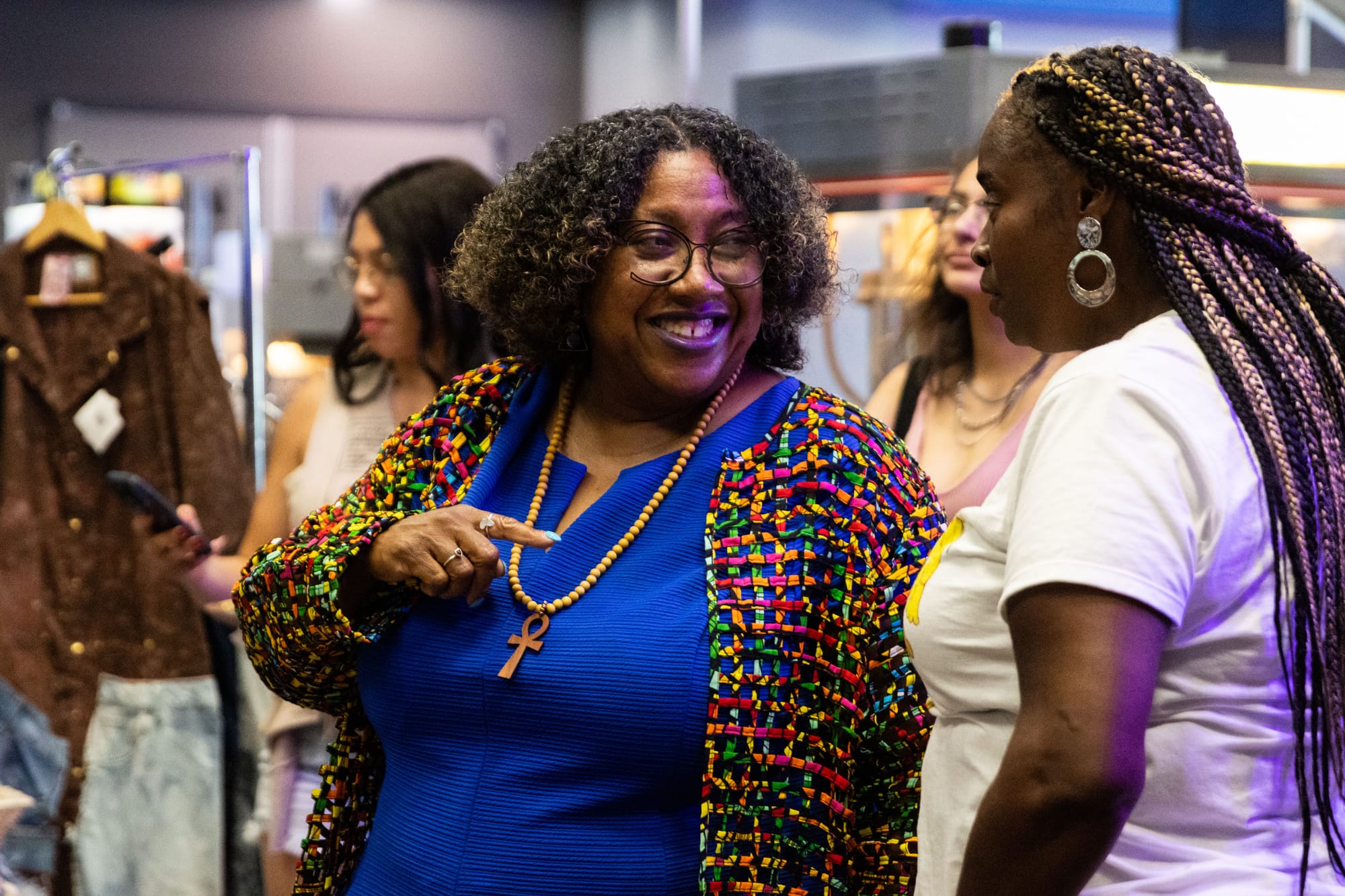 People speak in front of vendors at an event