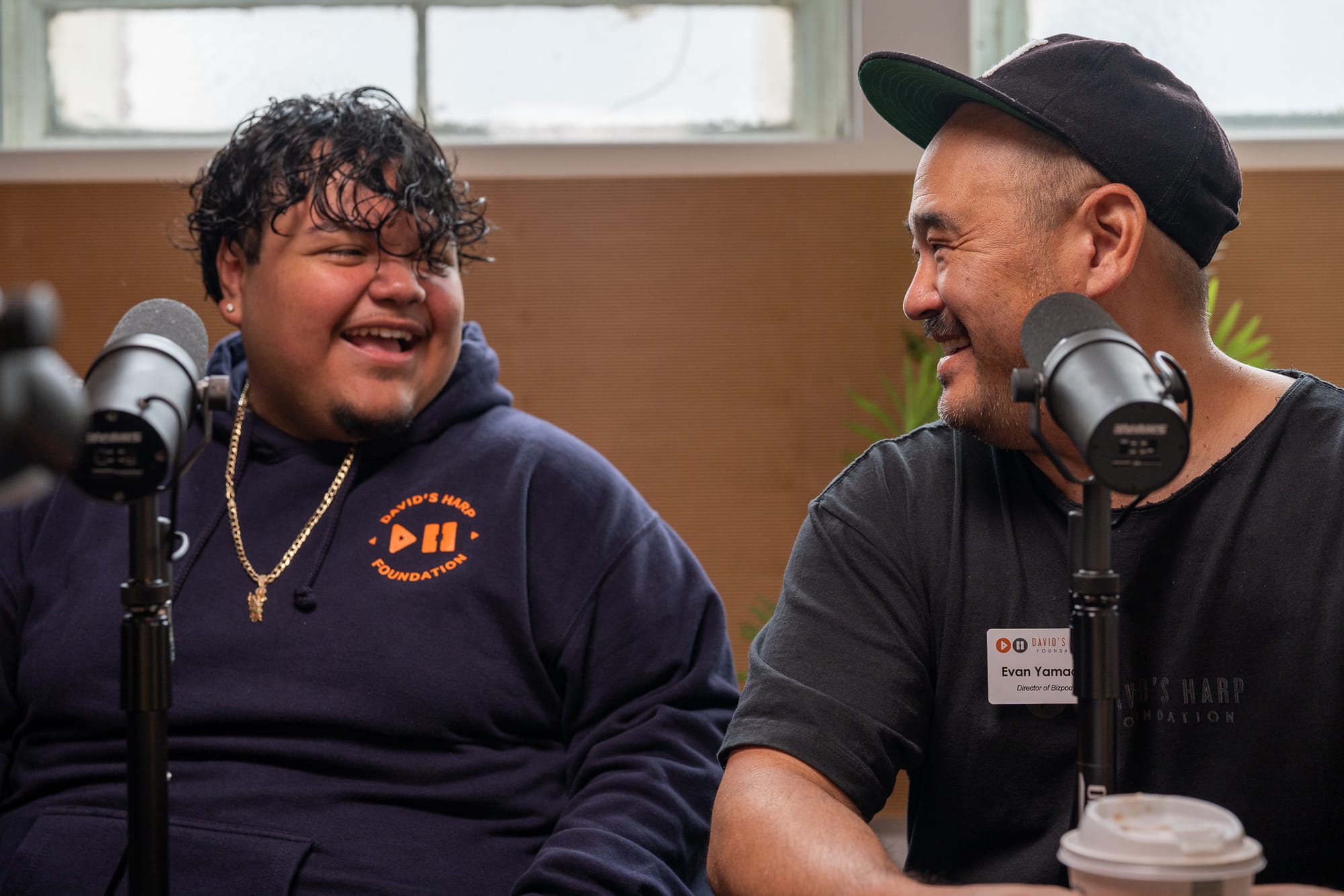 Two people talk into microphones.