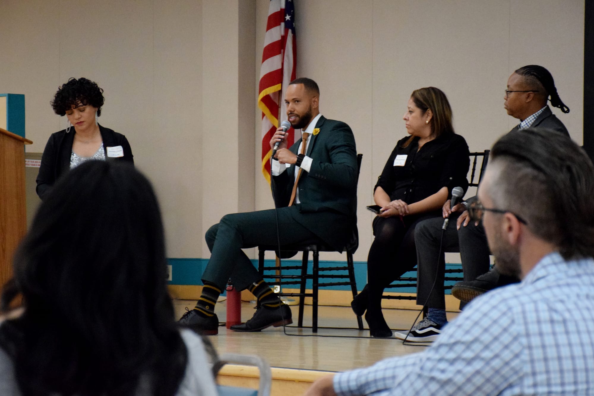 A man speaks sitting on a panel during a conference