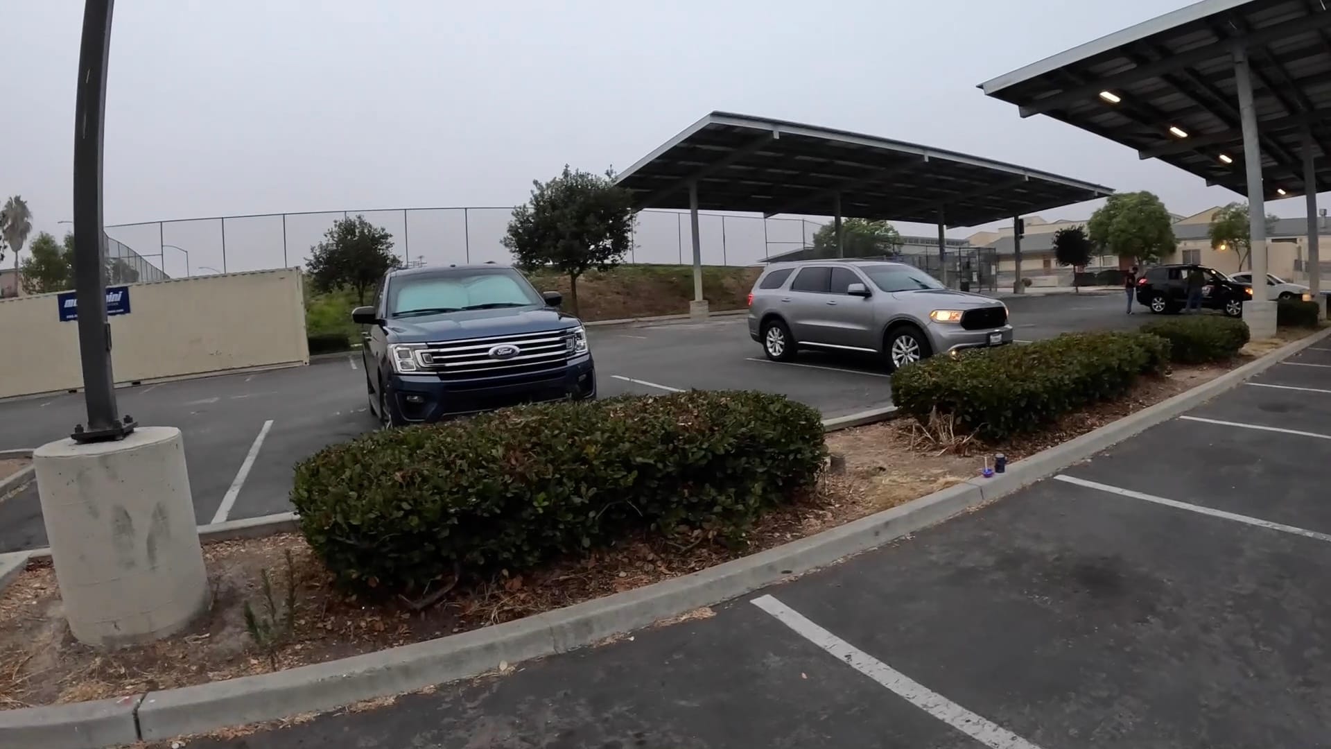 Photo of two cars in a parking lot under an overcast sky 