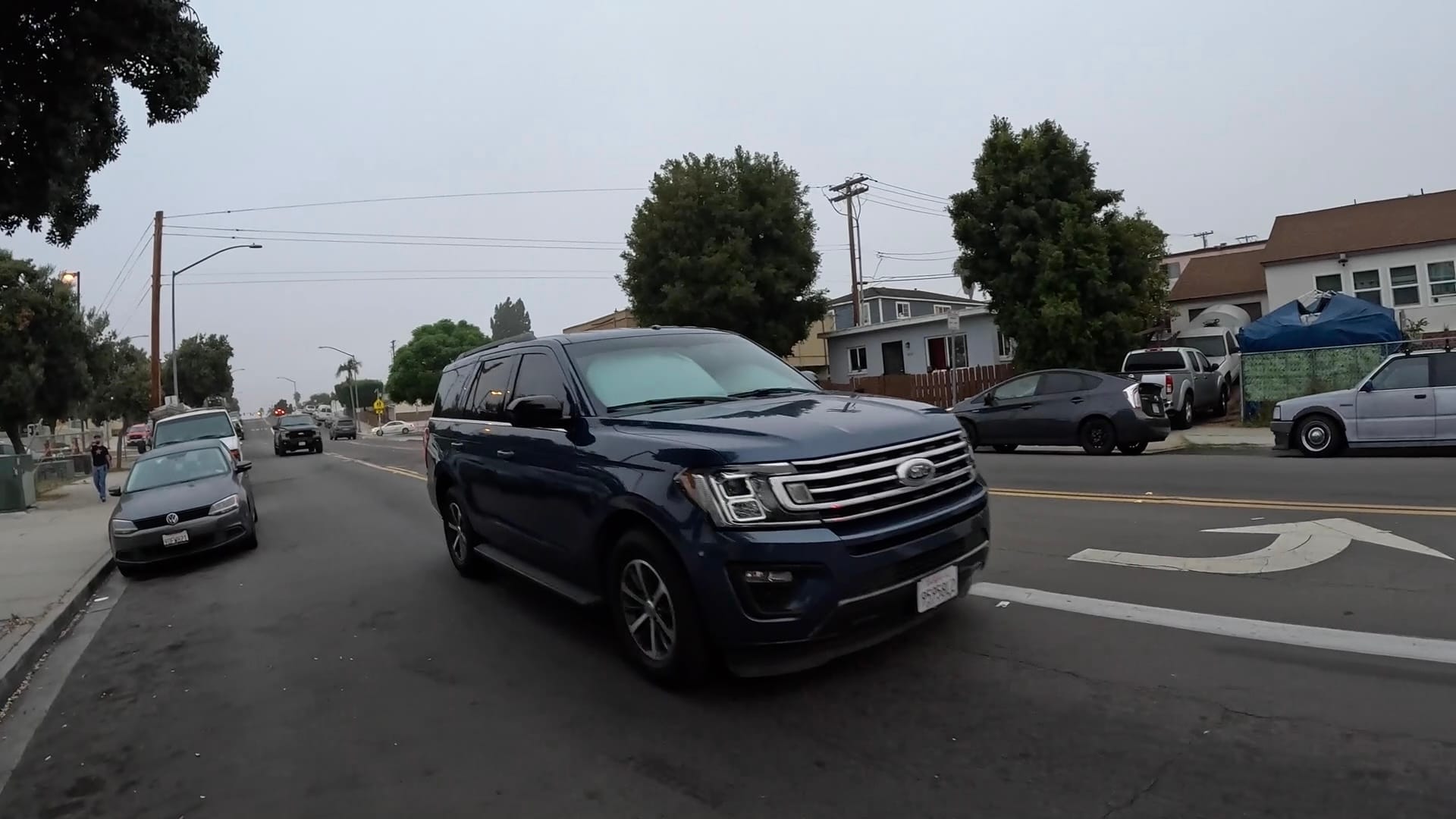 A Ford SUV drives down the street of a neighborhood 