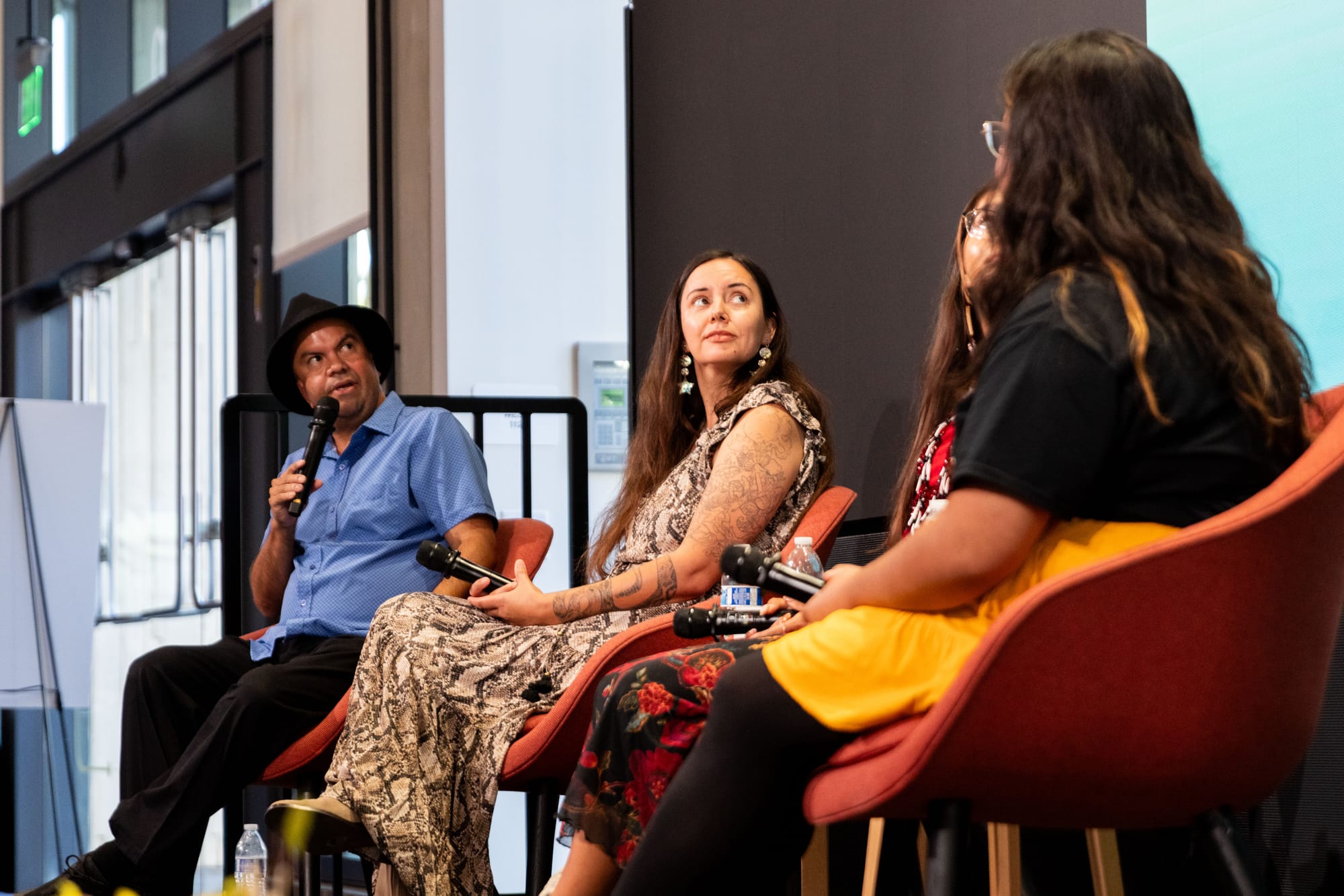 Four people sit talking onstage for a panel
