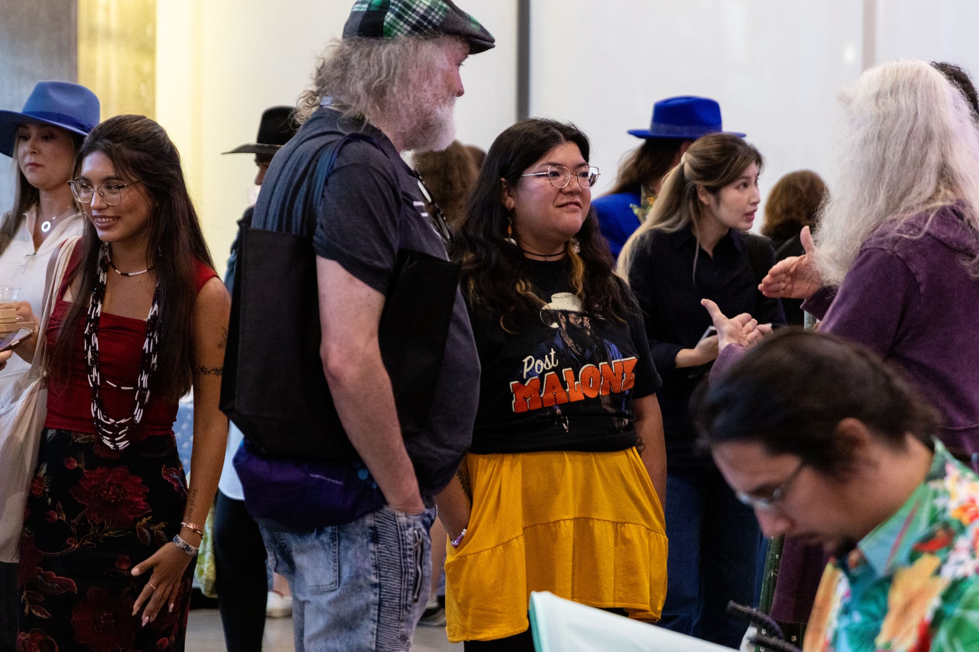 A group of people stand in a room talking during an event