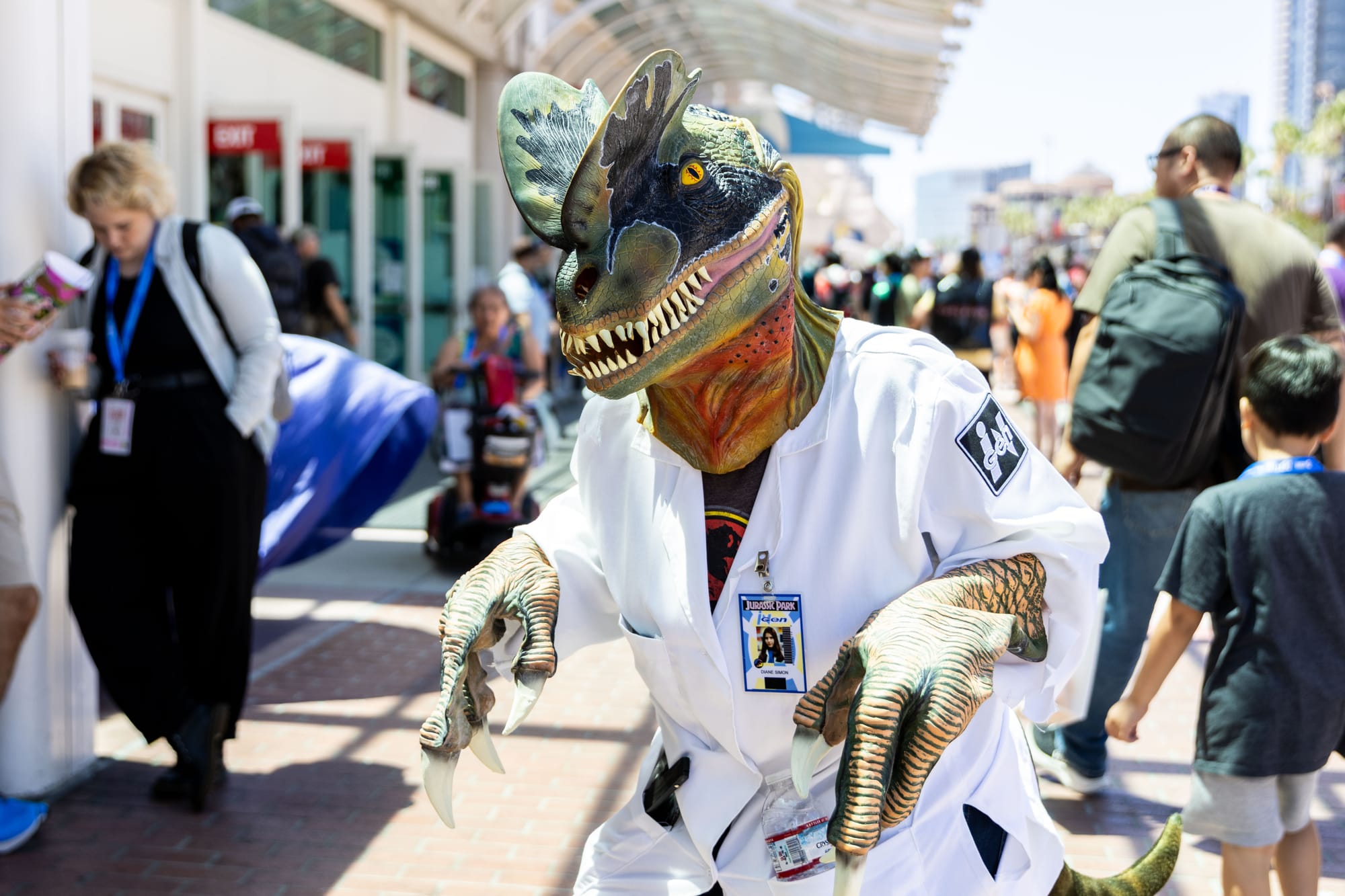 A person wears a dinosaur costume with a lab coat