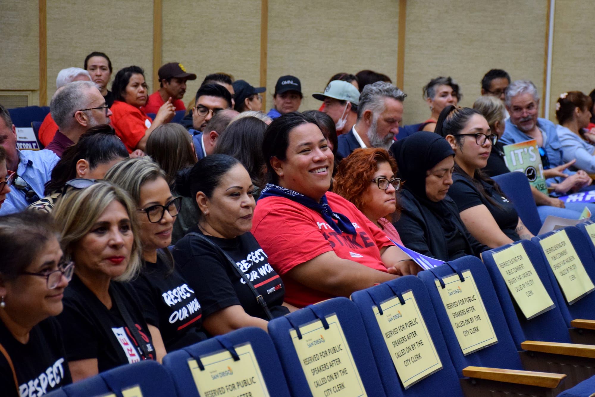 People sit in chairs at a city council meeting