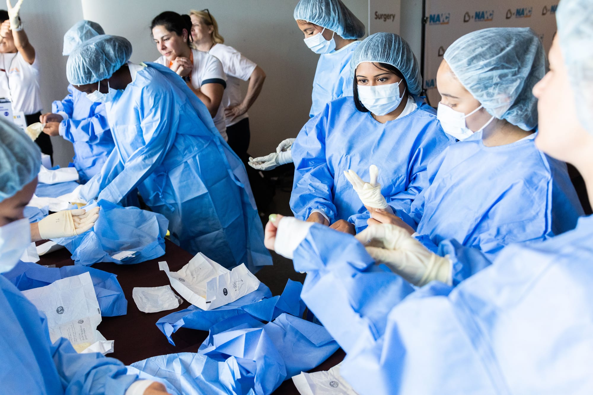 High school students don surgical clothing covers in a workshop 