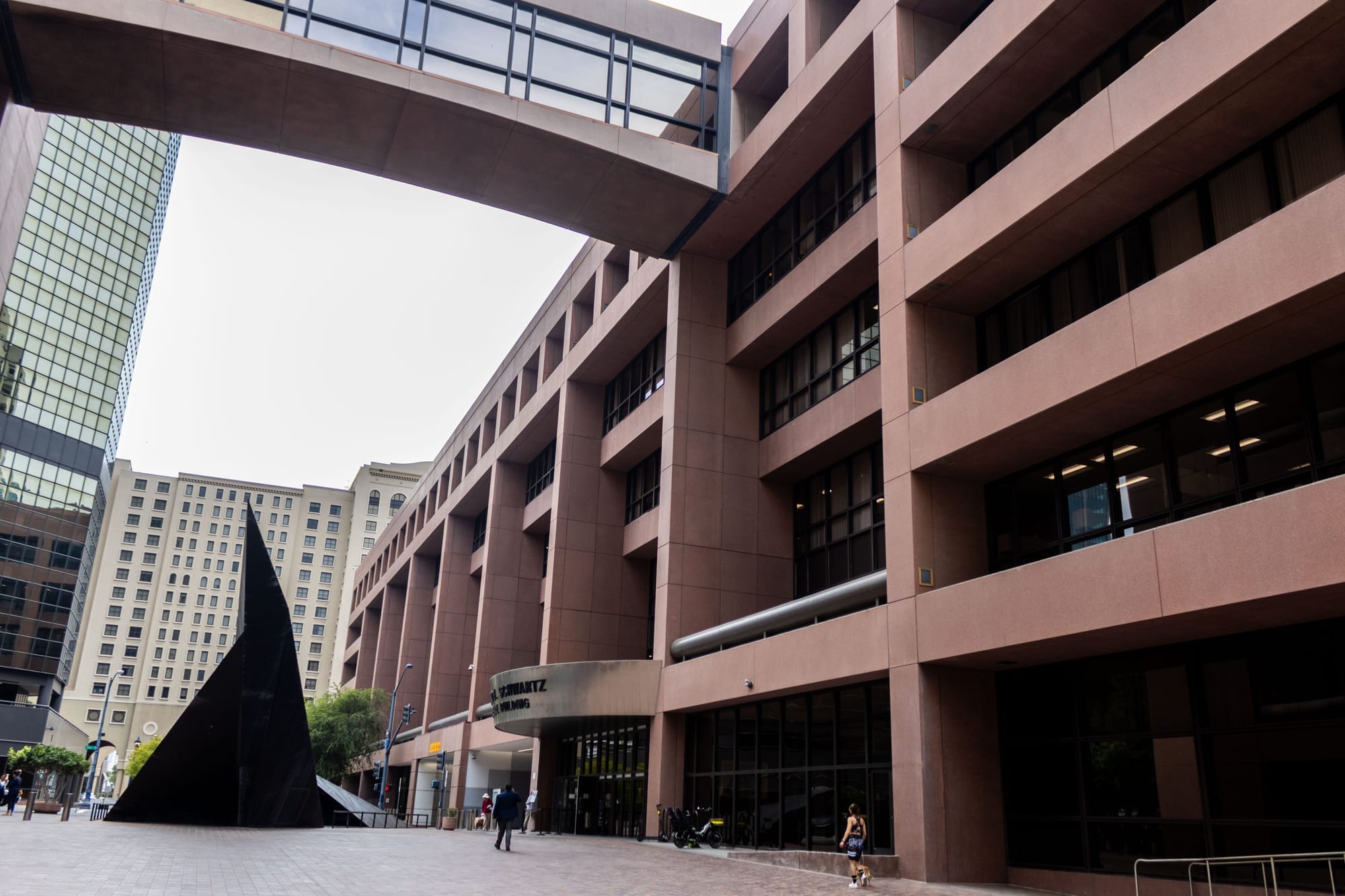 Picture of a brown, five story building with a bridge