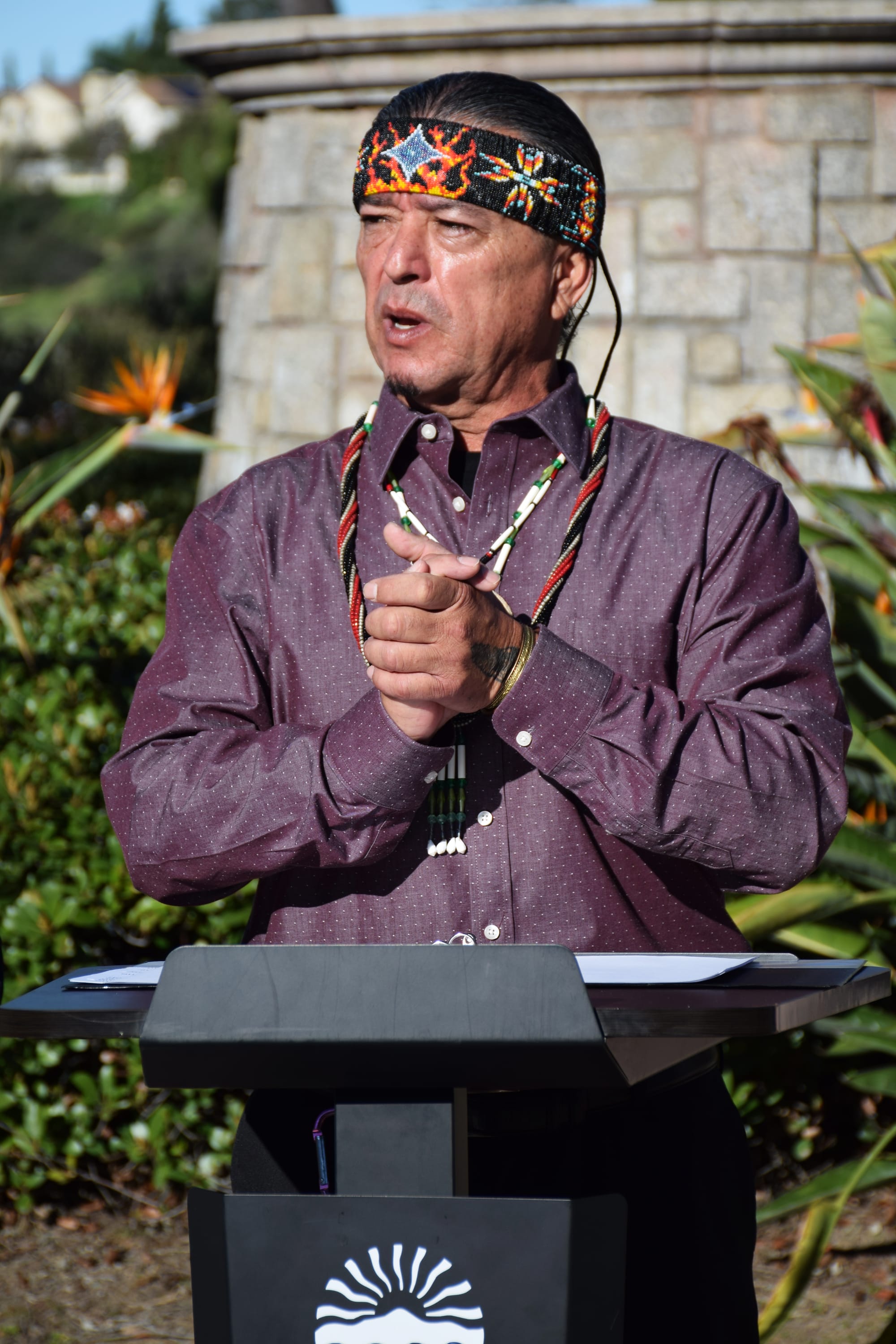 A man speaks at a podium outside during an event