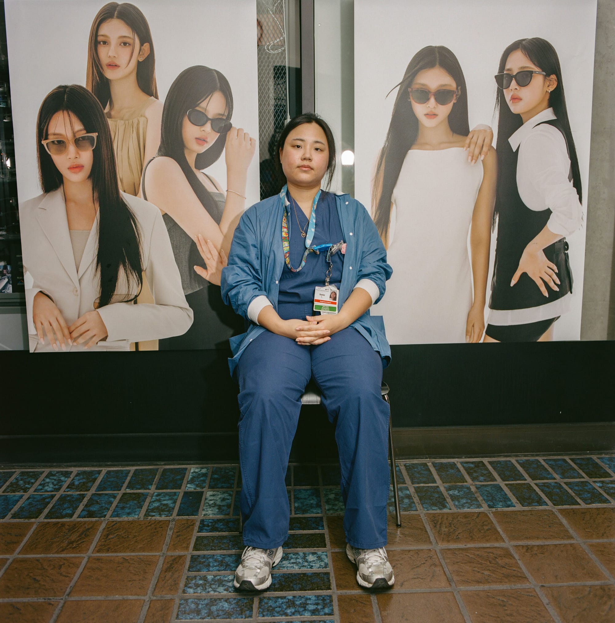 A nurse sits in front of two posters of other people