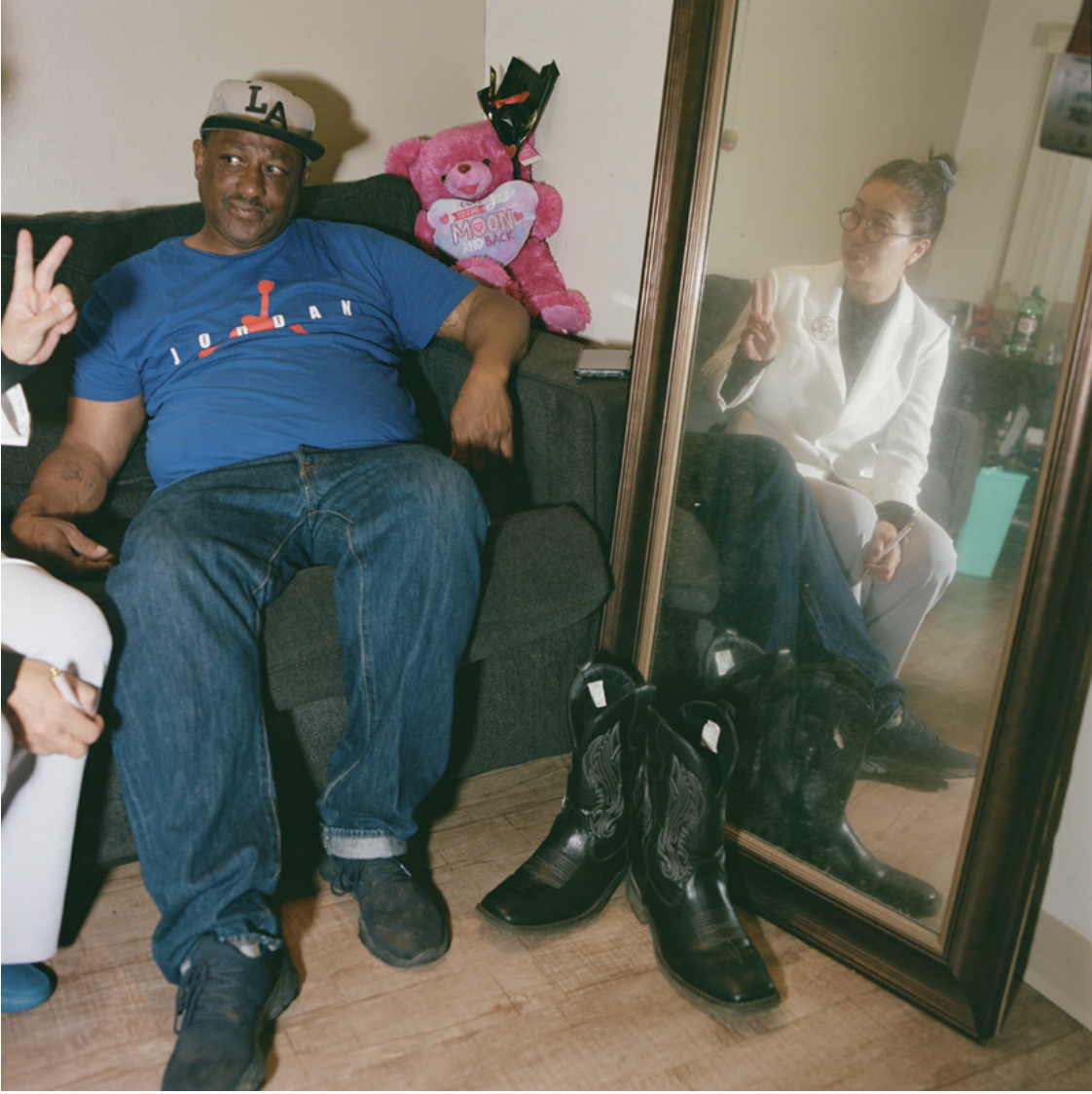 A woman sits on the couch with a patient. Her image is reflected in a mirror.