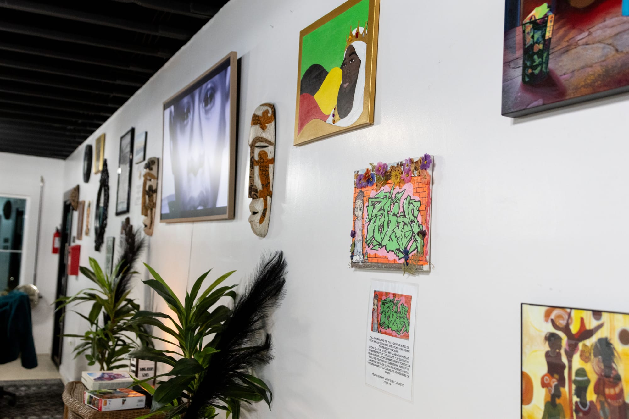 Side angle photo of a wall with art displayed on it