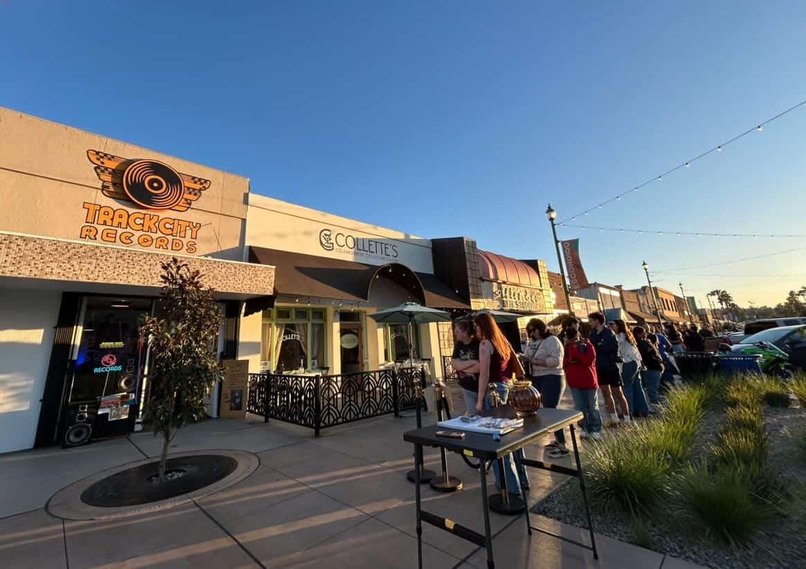 People wait in line outside a storefront that says Track City Records